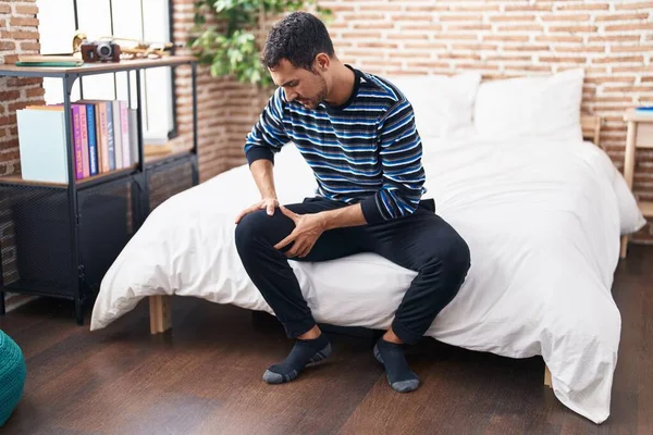 Young Hispanic Man Suffering Knee Injury Sitting Bed Bedroom — Photo