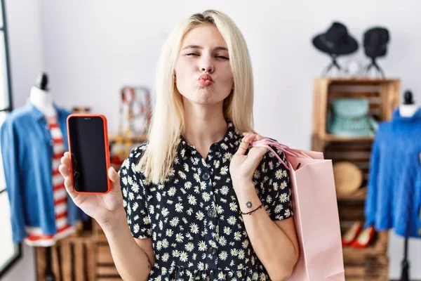 Junge Blonde Frau Mit Einkaufstaschen Die Den Smartphone Bildschirm Zeigen — Stockfoto