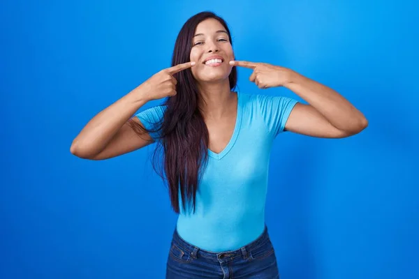 Young Hispanic Woman Standing Blue Background Smiling Cheerful Showing Pointing — ストック写真