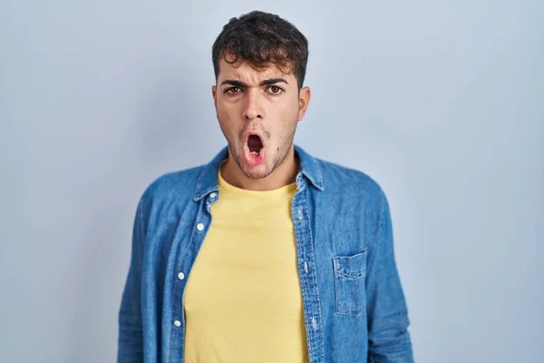 Junger Hispanischer Mann Steht Vor Blauem Hintergrund Schockgesicht Sieht Skeptisch — Stockfoto