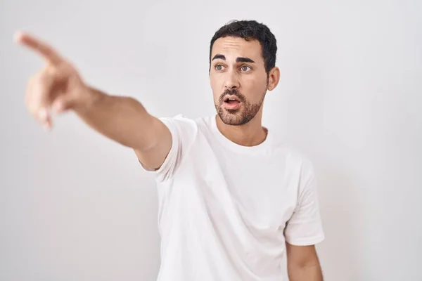 Handsome Hispanic Man Standing White Background Pointing Finger Surprised Ahead — Zdjęcie stockowe