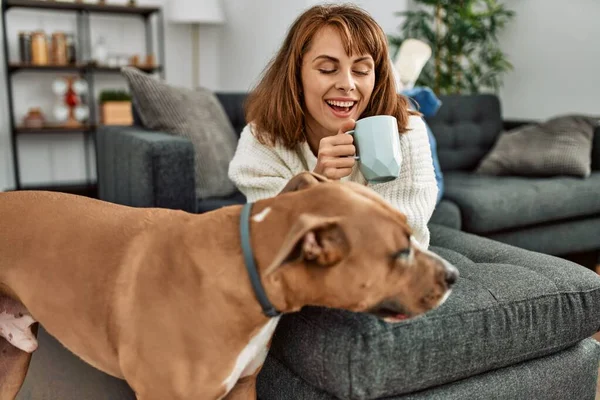 Junge Kaukasierin Trinkt Kaffee Liegend Auf Sofa Mit Hund Hause — Stockfoto