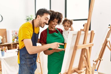 Couple and daughter smiling confident drawing at art studio
