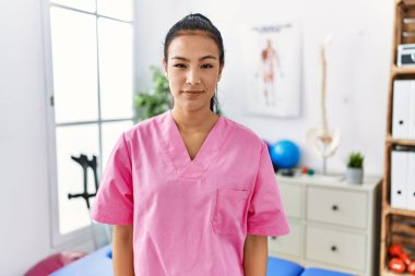 Ağrı kesici kliniğinde çalışan genç İspanyol kadın yüzünde ciddi bir ifadeyle rahatlamış. Basit ve doğal bir şekilde kameraya bakıyorsun.. 