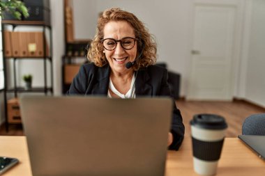 Middle age caucasian call center agent woman working at the office.