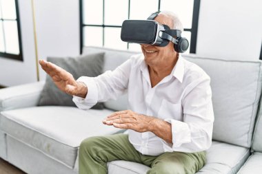 Son sınıf öğrencisi evde sanal gerçeklik gözlüğü kullanarak video oyunu oynuyor.