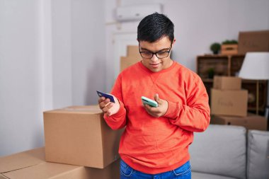 Down sendromlu adam yeni evinde akıllı telefon ve kredi kartı kullanıyor.