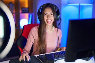 Genç İspanyol kadın video oyunları oynuyor. Dilini komik bir ifadeyle dışarı çıkarıyor. duygu kavramı. 