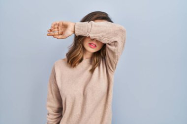 İzole edilmiş arka planda duran genç bir kadın kollarıyla gözlerini kapatıyor, ciddi ve üzgün görünüyor. Görme, saklama ve reddetme konsepti 