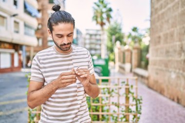 Sokakta sigara saran genç bir İspanyol.