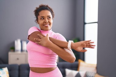 Afro-Amerikalı kadın gülümsüyor evde kendine güvenen bir kol.