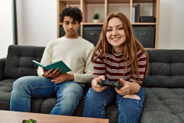 Kvinna Spelar Spel Medan Olycklig Pojkvän Läsa Bok Hemma — Stockfoto