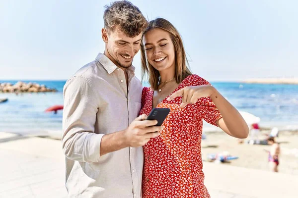 Unga Latinamerikanska Par Semester Ler Glada Med Hjälp Smartphone Stranden — Stockfoto