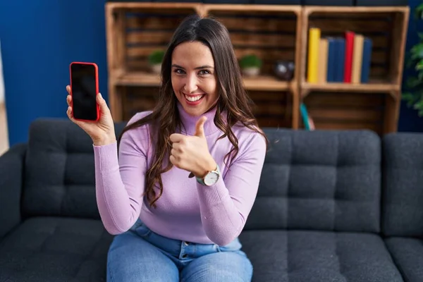 Young Brunette Woman Holding Smartphone Showing Blank Screen Smiling Happy — Stock fotografie