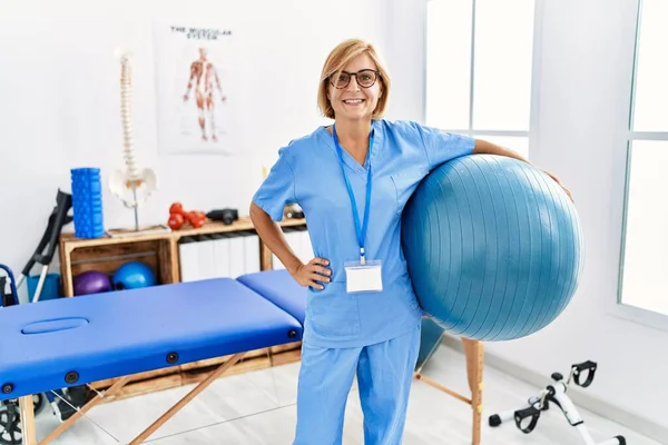 Mujer Rubia Mediana Edad Que Usa Uniforme Fisioterapeuta Sosteniendo Pelota —  Fotos de Stock