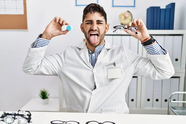 Young Optician Man Holding Glasses Contact Lenses Sticking Tongue Out — 图库照片