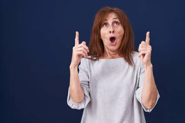 Middle Age Woman Standing Blue Background Amazed Surprised Looking Pointing — Stock fotografie