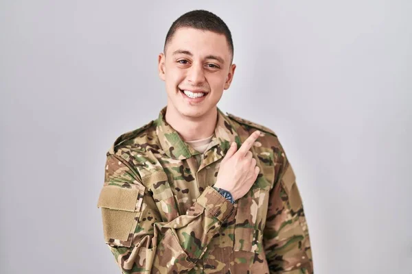 Młody Człowiek Mundurze Armii Kamuflażu Wesoły Uśmiechem Twarzy Wskazującym Ręką — Zdjęcie stockowe
