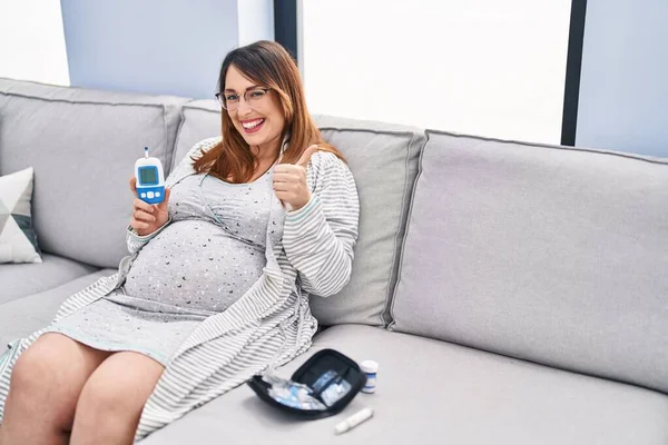 Těhotná Žena Pomocí Monitoru Krevního Tlaku Doma Usmívá Šťastný Pozitivní — Stock fotografie