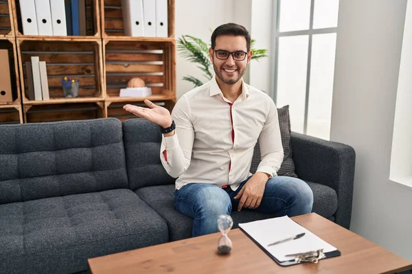 Joven Hispano Con Barba Trabajando Consultorio Sonriente Alegre Presentando Señalando — Foto de Stock