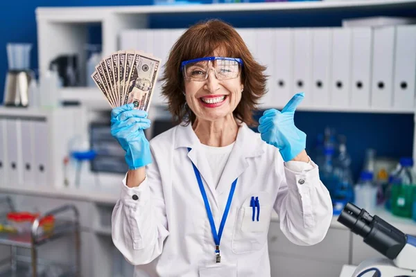 Женщина Средних Лет Работающая Лаборатории Учёных Держит Деньги Улыбаясь Счастливой — стоковое фото