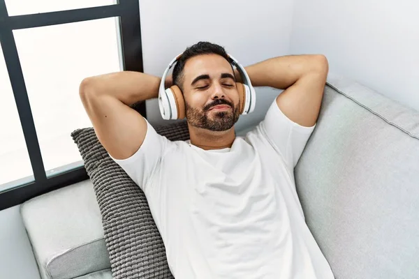 Νεαρός Ισπανός Που Ακούει Μουσική Ξαπλωμένος Στον Καναπέ Στο Σπίτι — Φωτογραφία Αρχείου