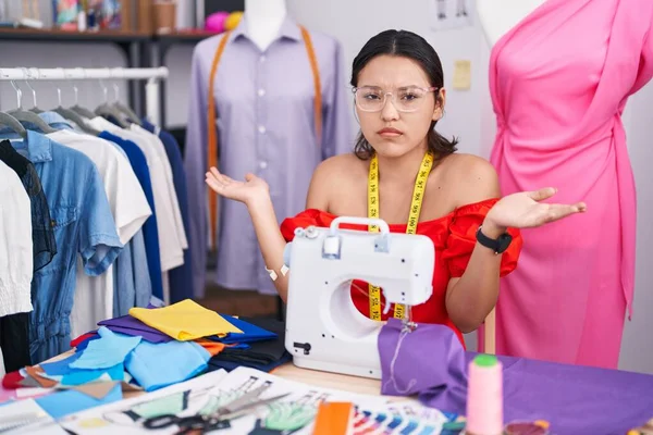 Hispanic Young Woman Dressmaker Designer Using Sewing Machine Clueless Confused — Stockfoto