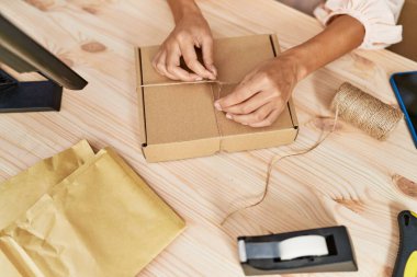 Young hispanic woman packing order at storehouse