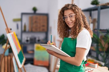 Sanat stüdyosunda kendine güvenen güzel İspanyol bir sanatçı çiziyor.