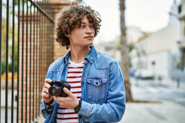 Genç İspanyol adam şehirde fotoğraf makinesi kullanıyor.