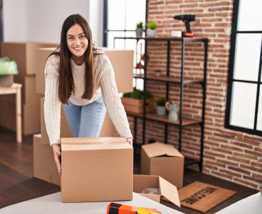 Genç bayan yeni evinde kendine güvenen bir paket tutuyor.