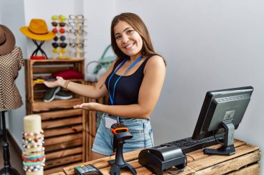 Perakende dükkanında açık mesajla afiş tutan esmer bir kadın gülümseyerek içeri girmeye davet ediyor. 