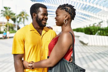 Genç Afro-Amerikan çifti mutlu bir şekilde gülümsüyor ve şehre sarılıyorlar..