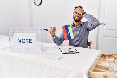 Siyasi seçim kampanyasında sakallı, elinde Venezuela bayrağı olan genç yakışıklı bir adam. 