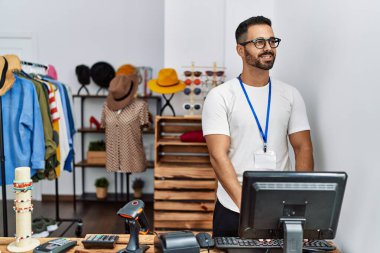 Genç İspanyol esnaf mağazada çalışırken gülümsüyor.