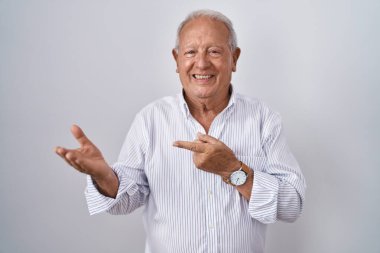İzole edilmiş arka planda duran yaşlı adam kameraya hayret ediyor ve gülümsüyor.. 