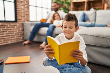 Family watching tv and son reading book at home