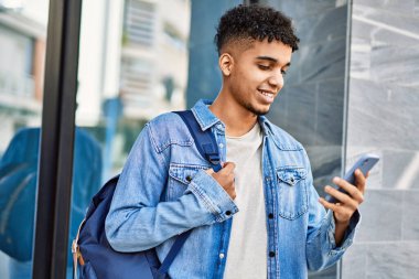 Üniversitede akıllı telefon kullanan İspanyol genç adam.
