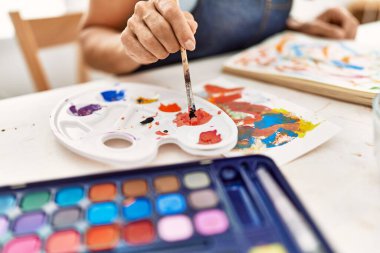 Resim stüdyosunda gülümseyen genç İspanyol sanatçı..