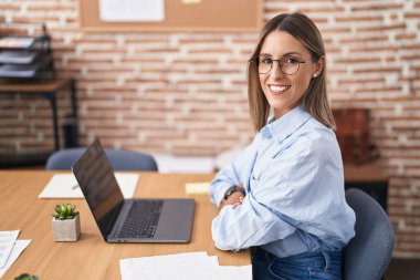 Young beautiful hispanic woman business worker smiling confident using laptop at office