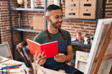 African american man artist smiling confident reading at art studio