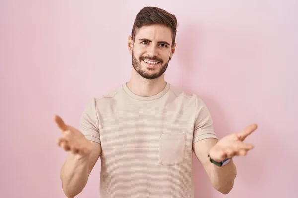 Hispanic Man Beard Standing Pink Background Smiling Cheerful Offering Hands — Stockfoto