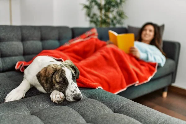 Junge Frau Liest Buch Auf Sofa Liegend Mit Hund Hause — Stockfoto