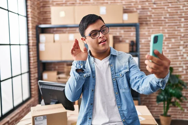 Down sendromlu adam ecommerce işçisi ofiste video görüşmesi yapıyor.