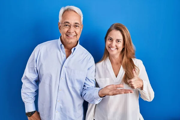Casal Hispânico Meia Idade Sobre Fundo Azul Mostrando Palma Mão — Fotografia de Stock