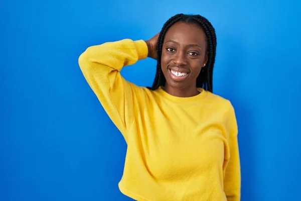 Mooie Zwarte Vrouw Staan Blauwe Achtergrond Glimlachen Zelfverzekerd Aanraken Haar — Stockfoto
