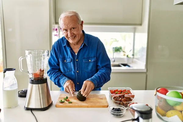 Starší Muž Usmívá Sebevědomě Řezání Avokádo Kuchyni — Stock fotografie