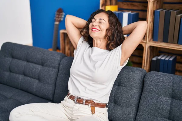 Middle Age Hispanic Woman Stretching Sitting Sofa Home — Stockfoto