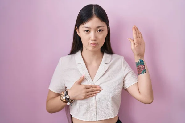 Chinês Jovem Mulher Sobre Fundo Rosa Jurando Com Mão Peito — Fotografia de Stock