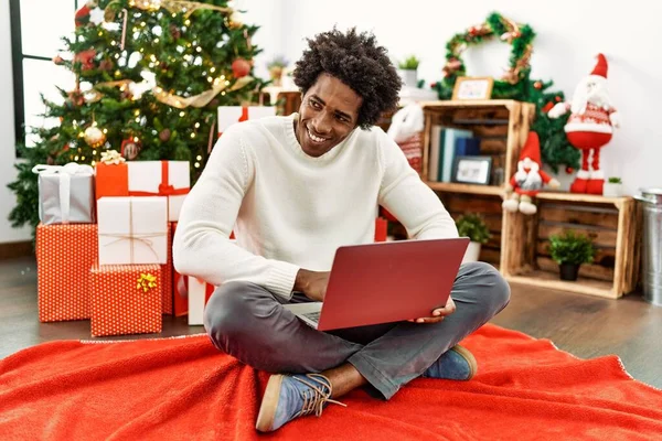 아프리카 미국인 집에서 크리스마스 바닥에 앉아서 노트북을 사용하고 있습니다 — 스톡 사진
